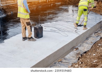 Waterproofing coating. Builder applying waterproofing bitumen mastic on concrete