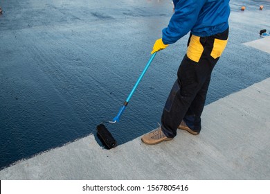 Waterproofing coating. Worker applies bitumen mastic on the foundation. Roofer cover the rooftop polymer modified bitumen waterproofing primer, with a roller brush. - Shutterstock ID 1567805416