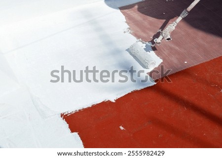 Waterproofing the floor of the house terrace with white rubber waterproofing paint applied with a roller. Waterproof anti-humidity seepage sealing paint.