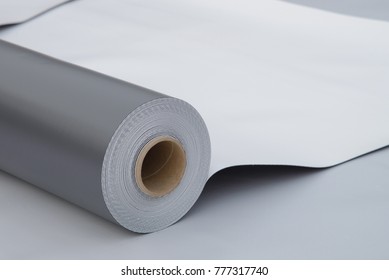 Waterproofing and insulation at construction site, opened pvc membrane roll lying on roof closeup. Copy space for your text. - Shutterstock ID 777317740
