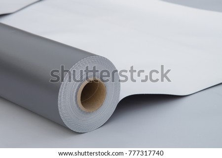 Waterproofing and insulation at construction site, opened pvc membrane roll lying on roof closeup. Copy space for your text.