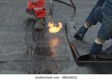 Waterproofing Roll Bituminous Material In The Trench. Construction Worker Manufacturer Uses A Gas Burner Propane Tank Fire.