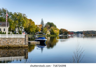 Waterside Houses among Trees with Boats Moored to Wooden Jetties on a Clear Autumn Day. Connecticut River, Essex, CT. - Powered by Shutterstock