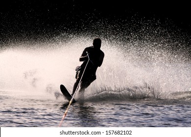 Waterskier silhouette with glowing spray - Shutterstock ID 157682102