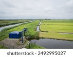 Waterworks pumping station Lange Weide Driebruggen. Dutch rural countryside scene in flat Holland farmland. Fish-friendly mechanism manages water level between polder and Enkele Wiericke Netherlands