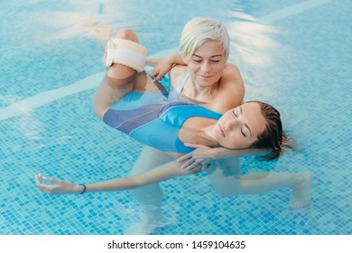 Watsu. The Direction Of Alternative Medicine, The Form Of Therapy In Warm Water. Master Watsu Conducts A Therapy Session For A Young Girl.