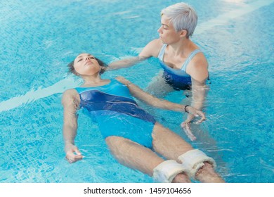 Watsu. The Direction Of Alternative Medicine, The Form Of Therapy In Warm Water. Master Watsu Conducts A Therapy Session For A Young Girl.