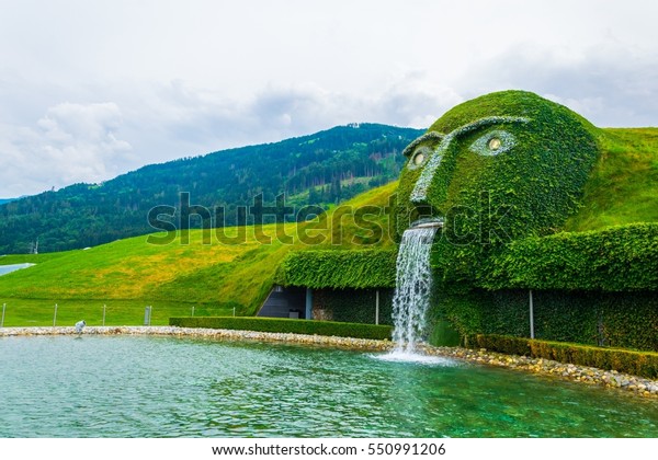 WATTENS, AUSTRIA, JULY 27, 2016: Fountain with giant head spitting water into a pond at swarovski Kristallwelten in Wattens, Austria.