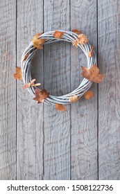 Wattle Wreath With Dry Autumn Leaves On Wooden Background, Text Space