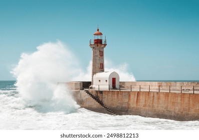 Wave crashing into lighthouse on the stone mole. The Felgueiras Lighthouse at Douro river mouth in Foz do Douro near Porto. Blue sky and Atlantic Ocean in the background. - Powered by Shutterstock