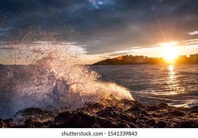Wave Hitting a Rock on the Sea. Golden Hour at Sunset