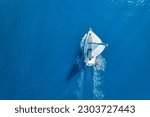 Wave and sail yacht on the sea as a background. 
Sea and waves from top view. Blue water background from top view. Top view from drone. Summertime vacation. Travel image