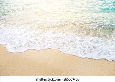 Wave of the sea on the sand beach with sunlight , for background