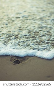 Wave washing away footprint