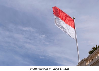 waved flag of Monaco against cloudy sky
