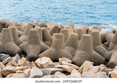 wave-dissipating concrete interlocking concrete structure designed and employed to minimize the effects of wave action upon shores and shoreline structures