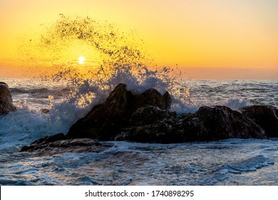 Waves of the Atlantic Ocean crashing against a rock at sunset. Seascape in Portugal, Miramar near Porto.