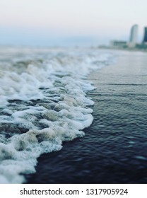 Waves Coming In On South Padre Island Late At Night With Hotel In Background 