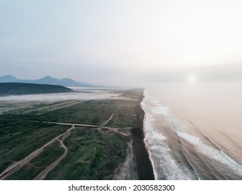 Waves And Cost Line Of Pacific Ocean Aerial Drone View. Sunrise And Volcanic Peaks On Horizon