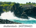 Waves crash against rock formations at Bombo on the South Coast of New South Wales, Australia.