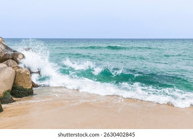 Waves crash gently against rocky shore at coastal beach during calm overcast day - Powered by Shutterstock - Get 15% off with code: PIKWIZARD15