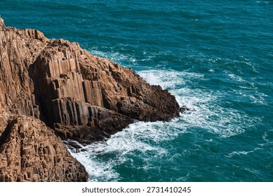 Waves crashed against the black hexagonal volcanic rock columns.
