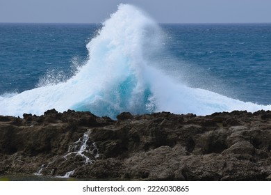 Waves Crashing Against Black Lava Rocks On The North Shore In Hawaii