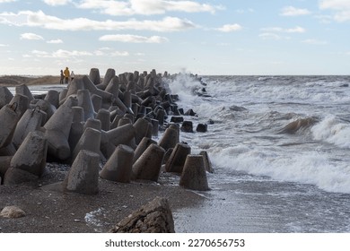 Waves crashing against breakwater consisting of gray concrete tetrapods. Liepaja, Latvia. Liepājas Ziemeļu mols - Shutterstock ID 2270656753