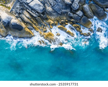 Waves crashing against rocky shoreline under clear blue sky at midday, showcasing the beauty of nature along the coast - Powered by Shutterstock