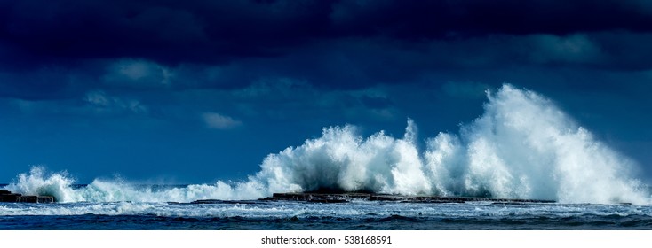 Waves crashing high in front of a blue sky at Coledate in NSW Australia - Powered by Shutterstock
