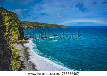 Waves crashing a Maui Beach with a rainbow in the distance on the Road To Hana, Maui, Hawaii