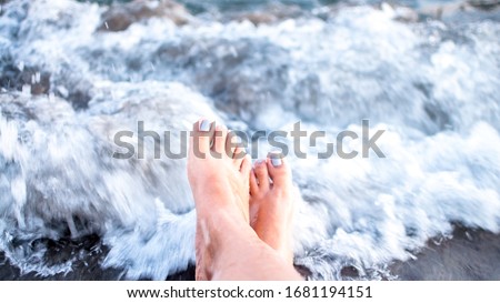 Waves crashing on a lady's feet while chilling on the beach (Morong, Bataan - Philippines).