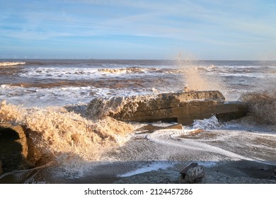 Waves crashing over rocks on a beach
 - Shutterstock ID 2124457286
