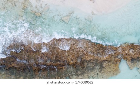 waves crashing in to shore drone shot from above white beach