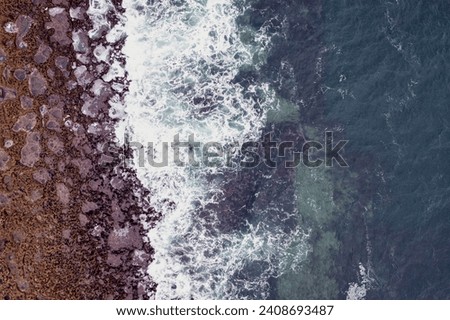 Waves crushing on rough stone coast line of Inishmore, Aran islands, county Galway, Ireland. Popular tourist sightseeing area with stunning Irish nature scenery. Aerial view.
