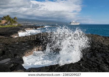 Waves hitting the beautiful rocky coast in Kona with a modern cruise ship anchored in the distance - Kona, Hawaii, USA