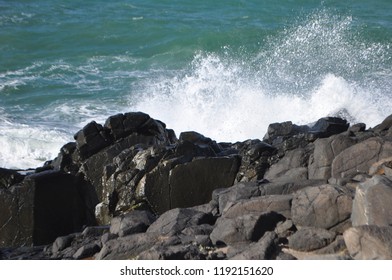 the waves are hitting the rocks