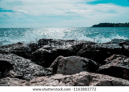 Waves hitting the rocks during hot summer day at French Riviera