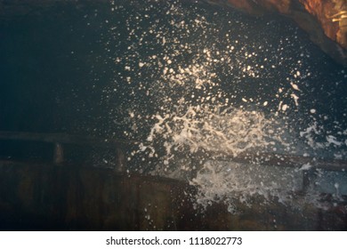 Waves hitting the viewing platform in a cave under a cliff