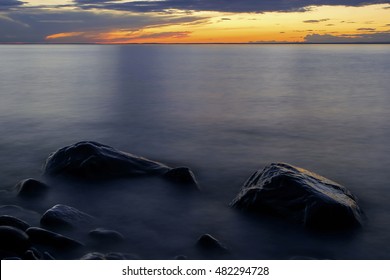 Waves Lap Around Rocks of Lake Superior's Wisconsin Shoreline During a Vibrant Sunset