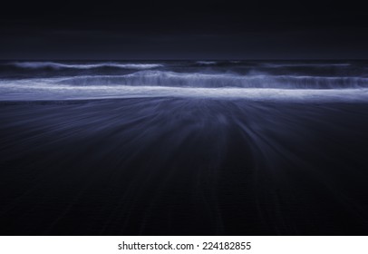 Waves at night on black sand beach