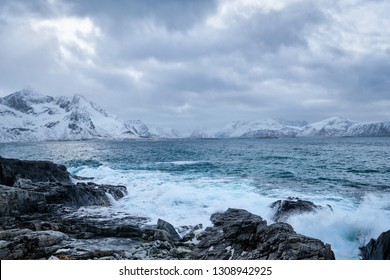 Waves of Norwegian sea crushing at rocky coast in fjord. Vikten, Lofoten islands, Norway