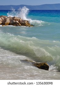 Waves on beautiful beach with stones in Podgora, Croatia