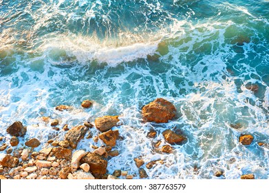 Waves on a rocky beach at sunset. Aerial view - Powered by Shutterstock