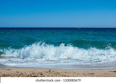 Waves on the seashore and a blue sky, clear blue water on a sunny day