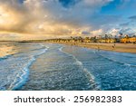 Waves in the Pacific Ocean and view of the beach at sunset, in Newport Beach, California