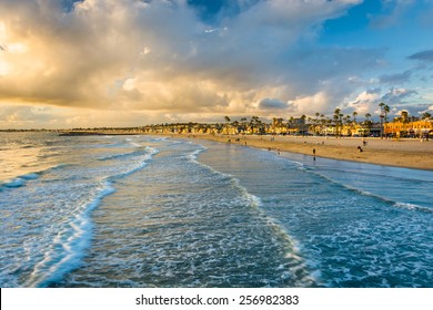 Waves in the Pacific Ocean and view of the beach at sunset, in Newport Beach, California
