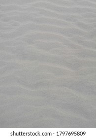 Waves pattern in a yellow and dry sandy beach. 