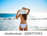 Waves, relax and back of woman at beach for summer adventure, peace and travel on holiday. Sun hat, bikini and female person with sunshine by ocean for tropical, island vacation and tourism in Bali