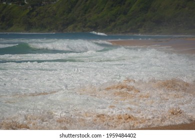 Waves rolling up on sandy beach - close up
